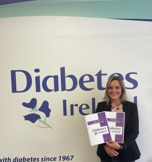 Doctor Kate Gajewska Standing in front of Diabetes Ireland Logo